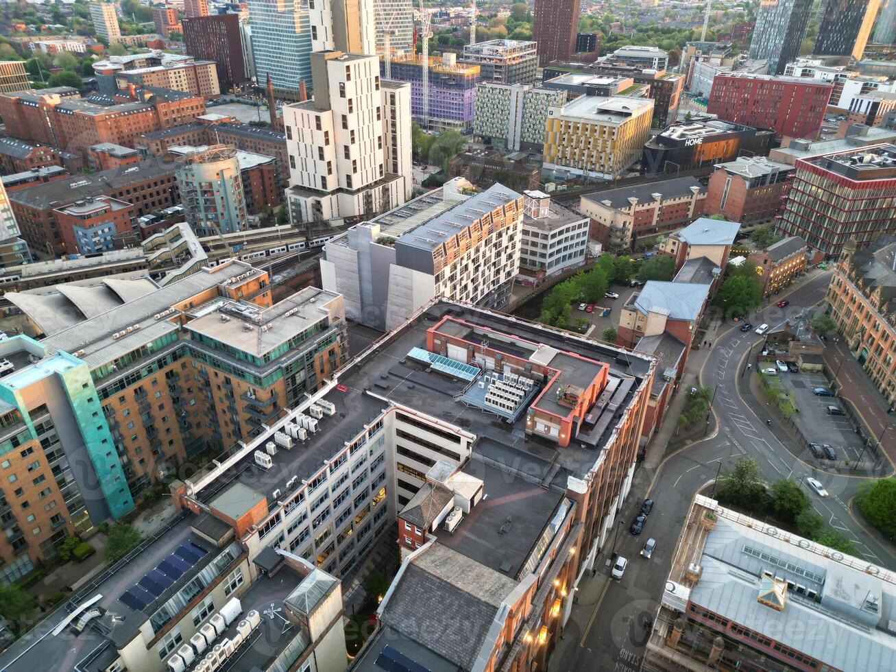 Aerial View of Greater Manchester City Centre and Tall Buildings During Golden Hour of Sunset. England UK. High Angle Footage Was Captured with Drone's Camera During Windy day of May 5th, 2024 photo