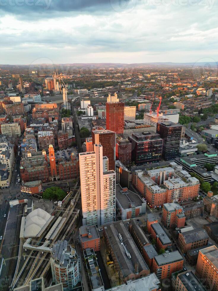 Aerial View of Greater Manchester City Centre and Tall Buildings During Golden Hour of Sunset. England UK. High Angle Footage Was Captured with Drone's Camera During Windy day of May 5th, 2024 photo
