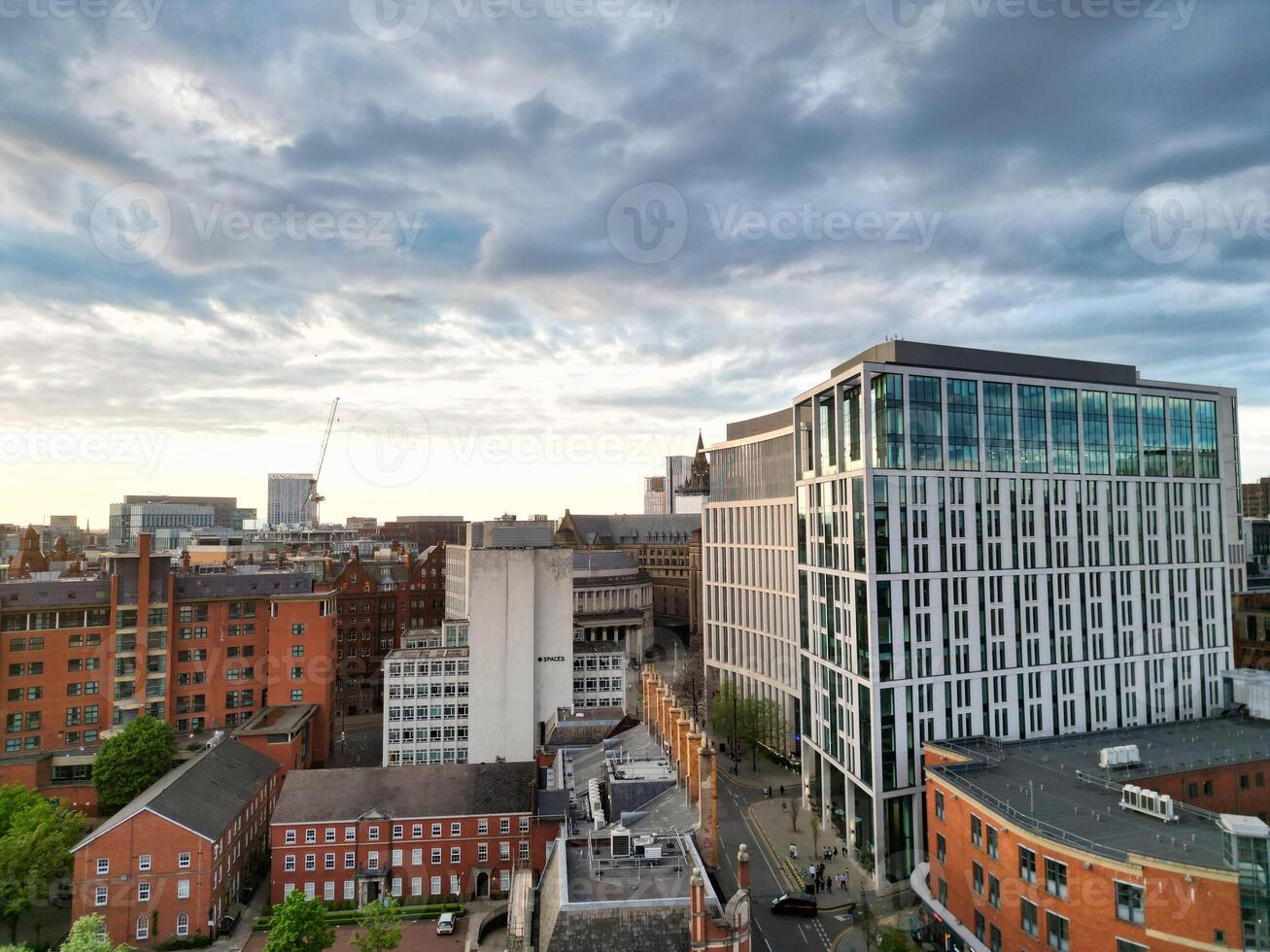 Aerial View of Greater Manchester City Centre and Tall Buildings During Golden Hour of Sunset. England UK. High Angle Footage Was Captured with Drone's Camera During Windy day of May 5th, 2024 photo