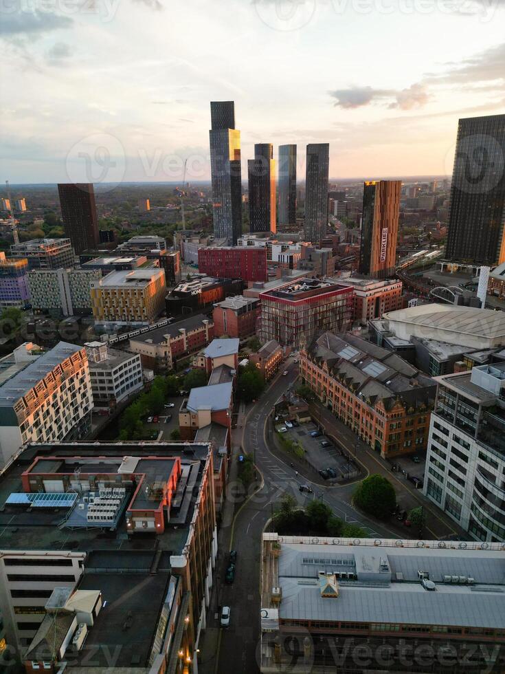 Aerial View of Greater Manchester City Centre and Tall Buildings During Golden Hour of Sunset. England UK. High Angle Footage Was Captured with Drone's Camera During Windy day of May 5th, 2024 photo