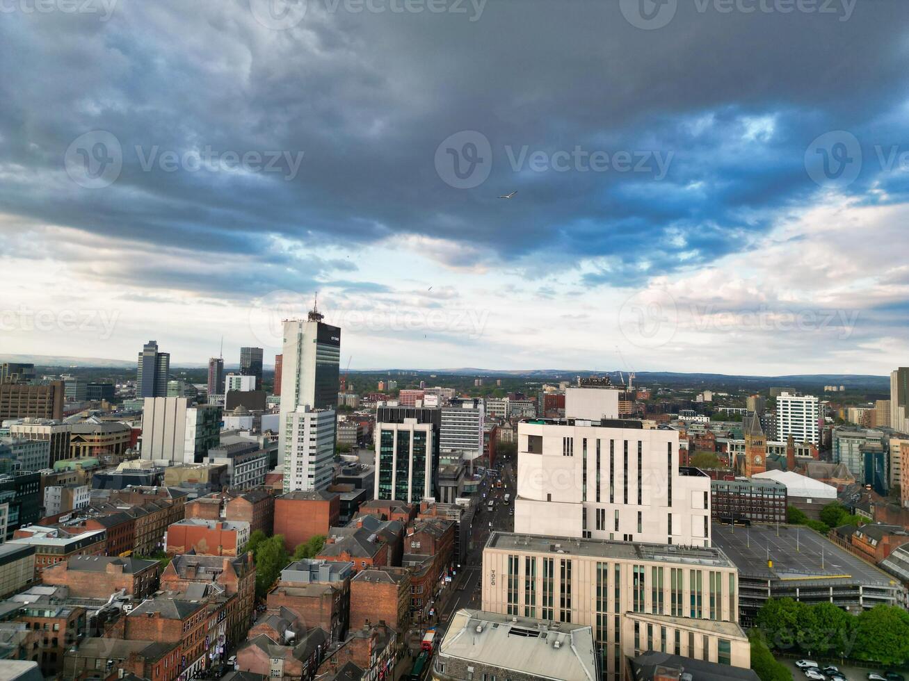 Aerial View of Greater Manchester City Centre and Tall Buildings During Golden Hour of Sunset. England UK. High Angle Footage Was Captured with Drone's Camera During Windy day of May 5th, 2024 photo