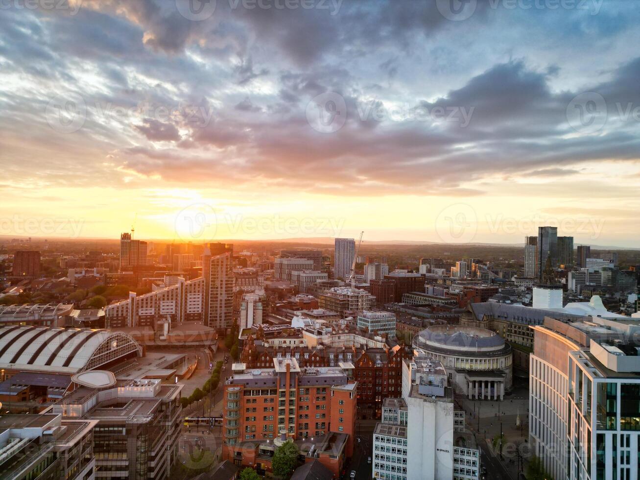 Aerial View of Greater Manchester City Centre and Tall Buildings During Golden Hour of Sunset. England UK. High Angle Footage Was Captured with Drone's Camera During Windy day of May 5th, 2024 photo