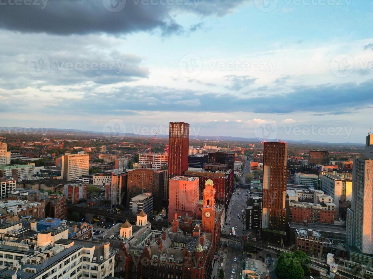 Aerial View of Greater Manchester City Centre and Tall Buildings During Golden Hour of Sunset. England UK. High Angle Footage Was Captured with Drone's Camera During Windy day of May 5th, 2024 photo