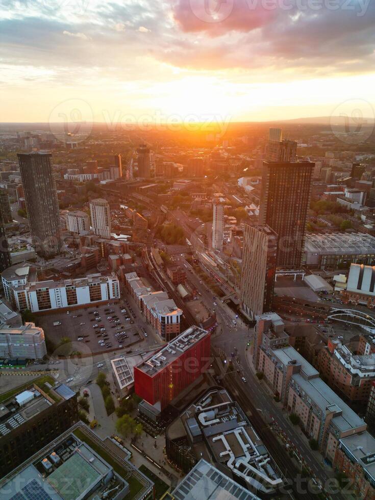 Aerial View of Greater Manchester City Centre and Tall Buildings During Golden Hour of Sunset. England UK. High Angle Footage Was Captured with Drone's Camera During Windy day of May 5th, 2024 photo
