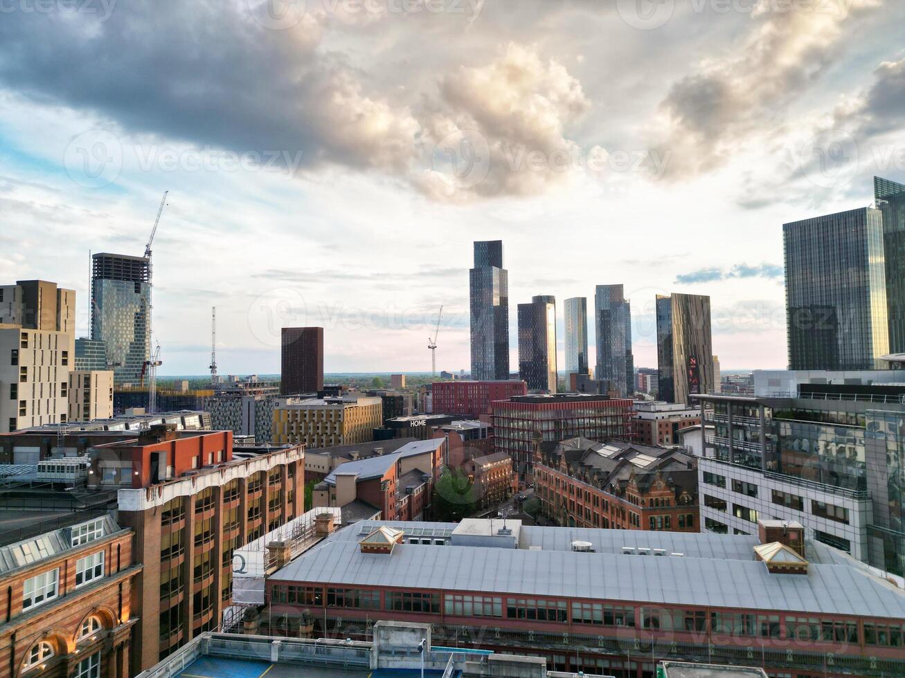 Aerial View of Greater Manchester City Centre and Tall Buildings During Golden Hour of Sunset. England UK. High Angle Footage Was Captured with Drone's Camera During Windy day of May 5th, 2024 photo