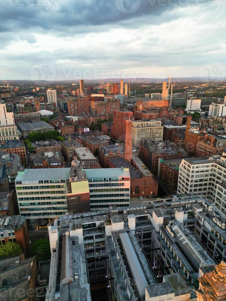Aerial View of Greater Manchester City Centre and Tall Buildings During Golden Hour of Sunset. England UK. High Angle Footage Was Captured with Drone's Camera During Windy day of May 5th, 2024 photo