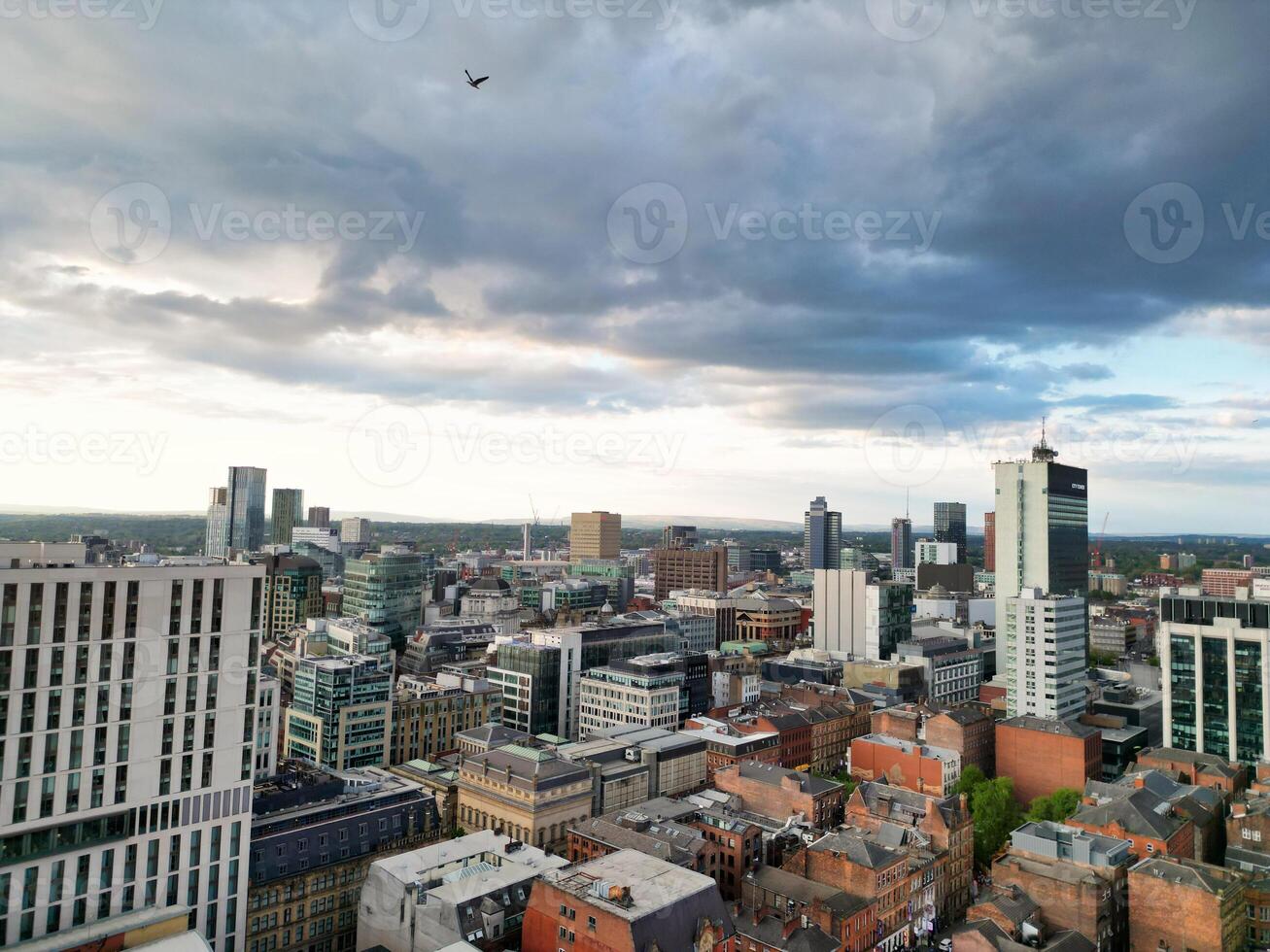 Aerial View of Greater Manchester City Centre and Tall Buildings During Golden Hour of Sunset. England UK. High Angle Footage Was Captured with Drone's Camera During Windy day of May 5th, 2024 photo