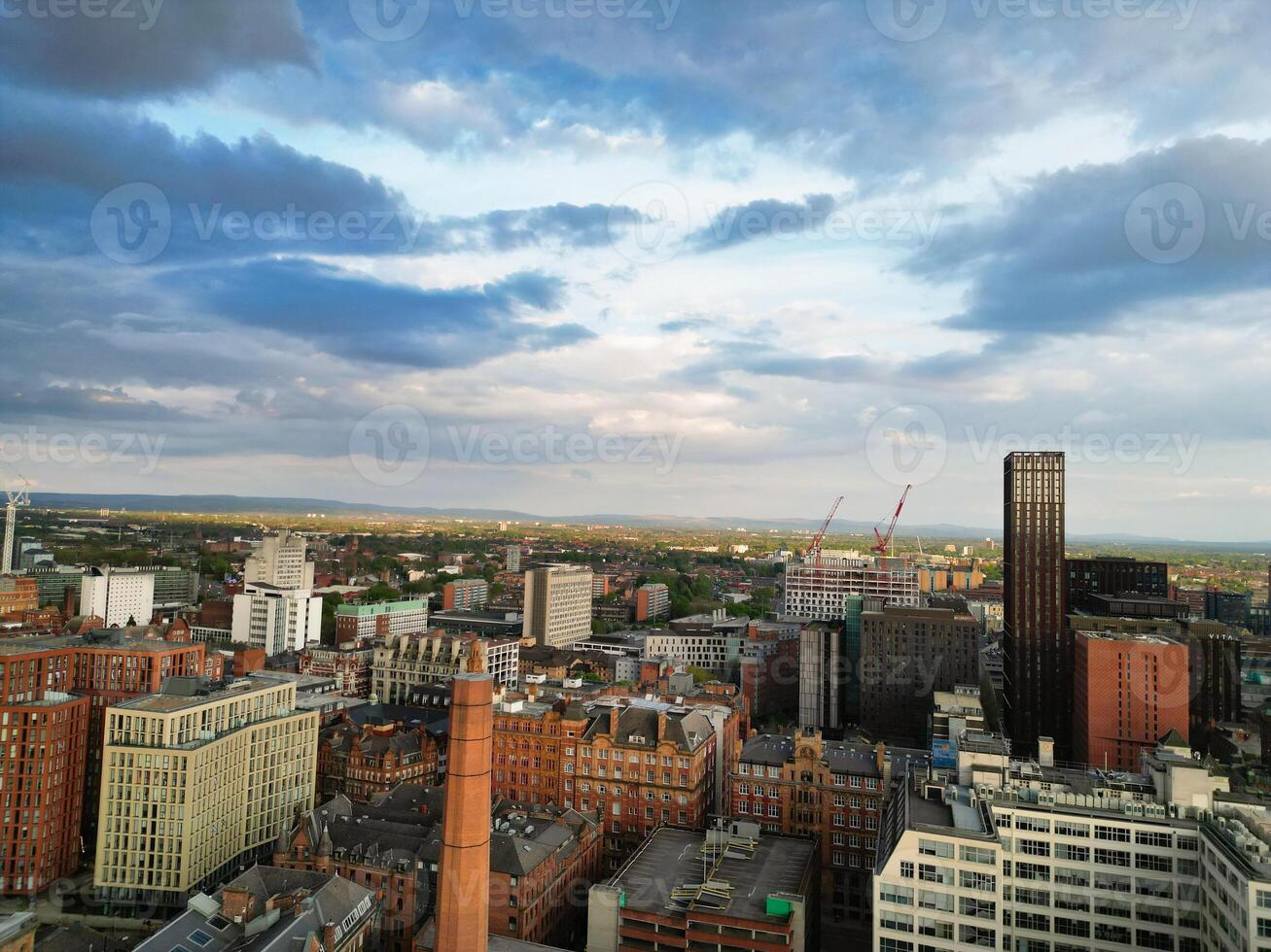 Aerial View of Greater Manchester City Centre and Tall Buildings During Golden Hour of Sunset. England UK. High Angle Footage Was Captured with Drone's Camera During Windy day of May 5th, 2024 photo