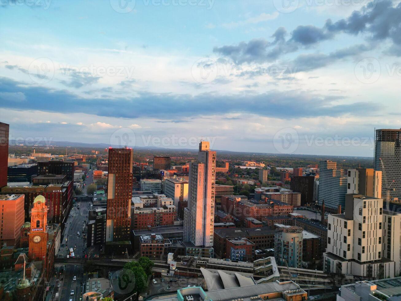 Aerial View of Greater Manchester City Centre and Tall Buildings During Golden Hour of Sunset. England UK. High Angle Footage Was Captured with Drone's Camera During Windy day of May 5th, 2024 photo