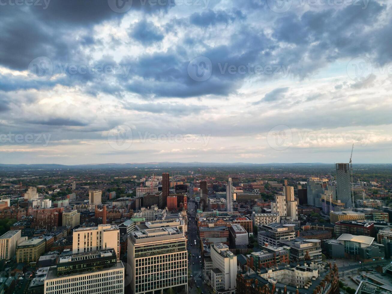 Aerial View of Greater Manchester City Centre and Tall Buildings During Golden Hour of Sunset. England UK. High Angle Footage Was Captured with Drone's Camera During Windy day of May 5th, 2024 photo