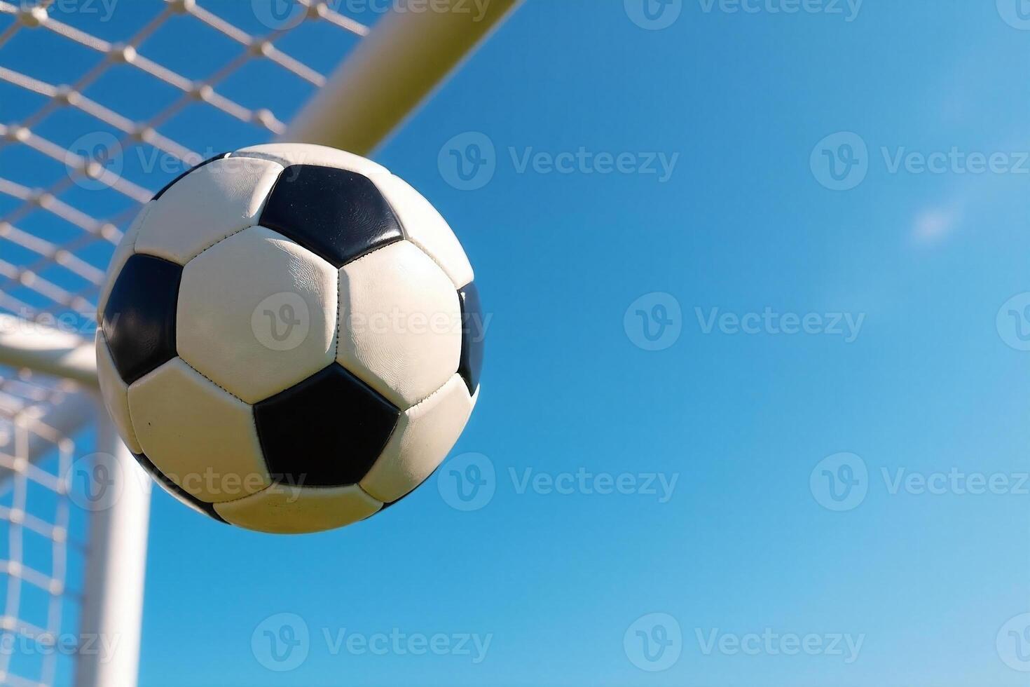 Soccer Ball Flying into Goal Net Against Blue Sky photo