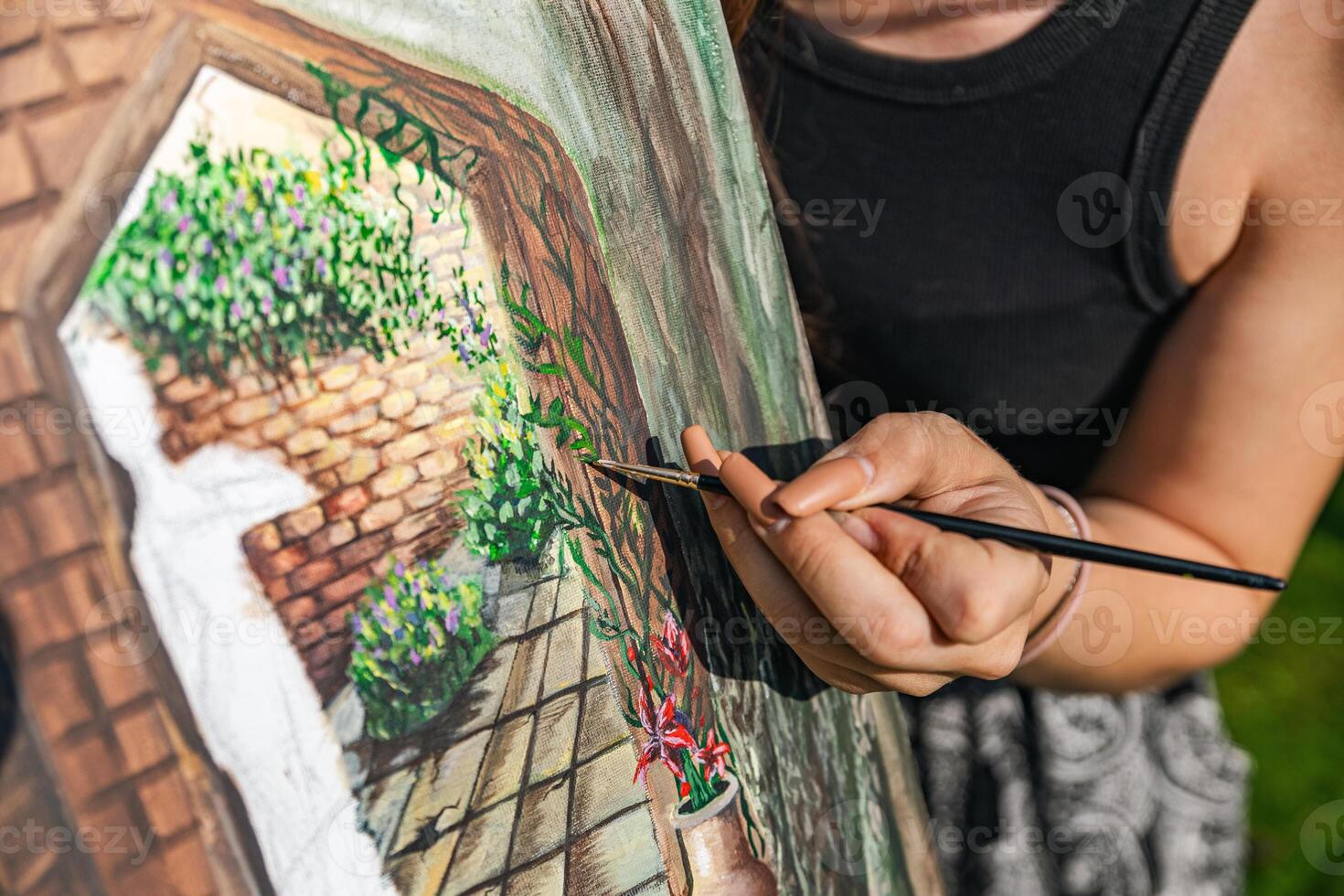 Close-up of someone skillfully painting on a canvas. The artwork looks like it depicts a rustic scene, possibly featuring elements like bricks or wood, giving it a cozy, homely feel. photo