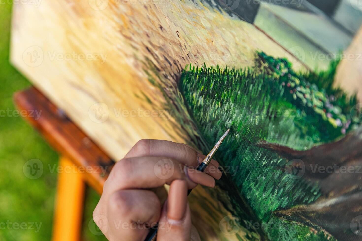 Close-up of someone skillfully painting on a canvas. The artwork looks like it depicts a rustic scene, possibly featuring elements like bricks or wood, giving it a cozy, homely feel. photo