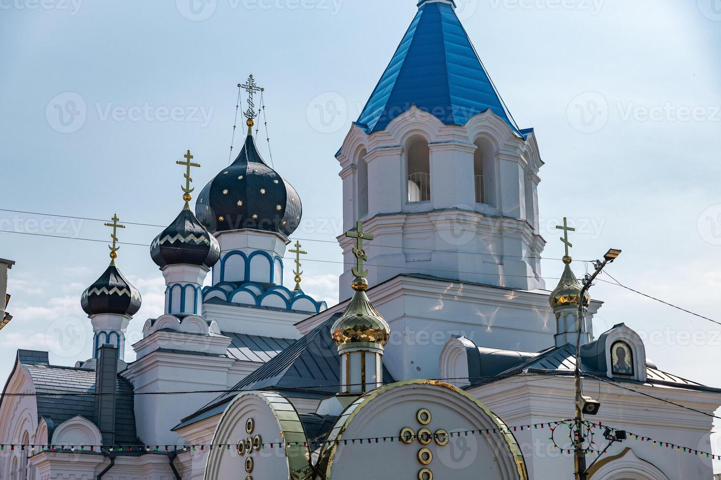 Traditional Eastern Orthodox church with classic architectural features. The building has distinct onion-shaped domes topped with crosses. photo