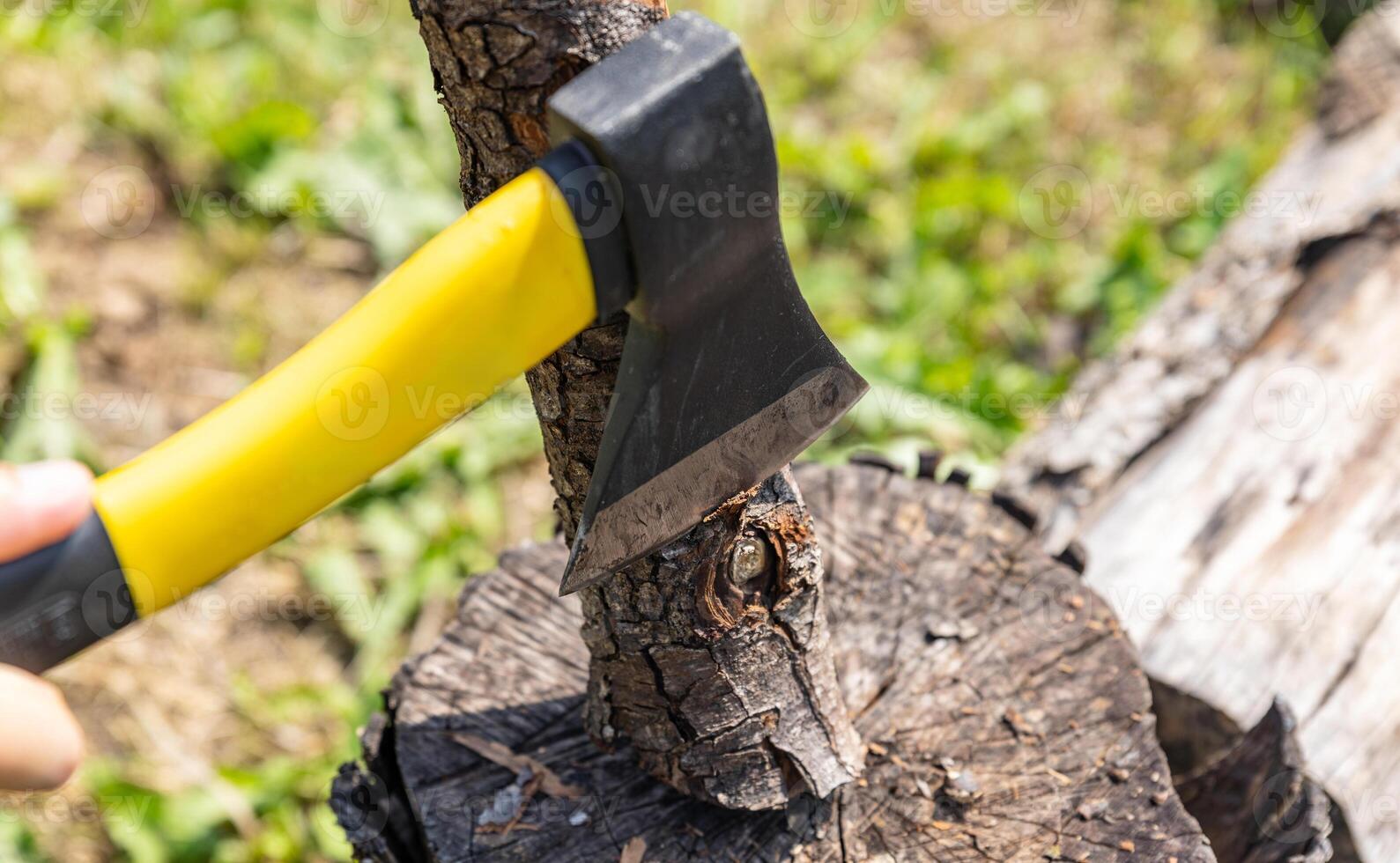 Steel axe, metal ax for wood chopping. Man holding heavy ax. Axe in lumberjack hands chopping or cutting wood trunks. photo