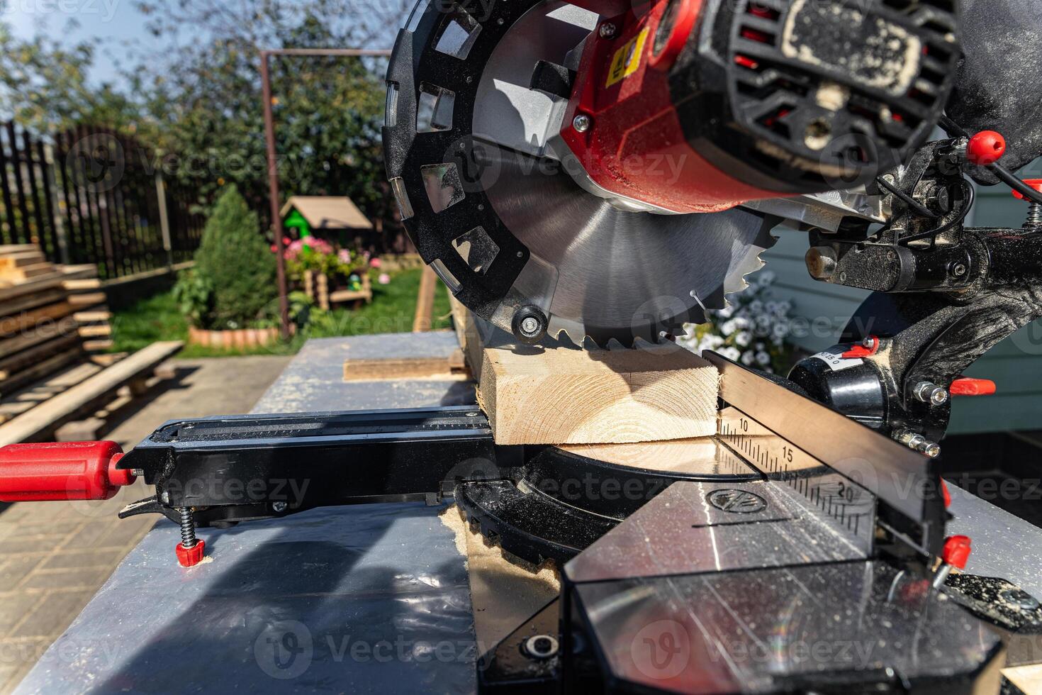 Using a miter saw to cut a piece of wood. Own carpentry workshop. Sawing a wooden board with a miter saw. Safe equipment for the furniture and construction industry. Close-up. photo