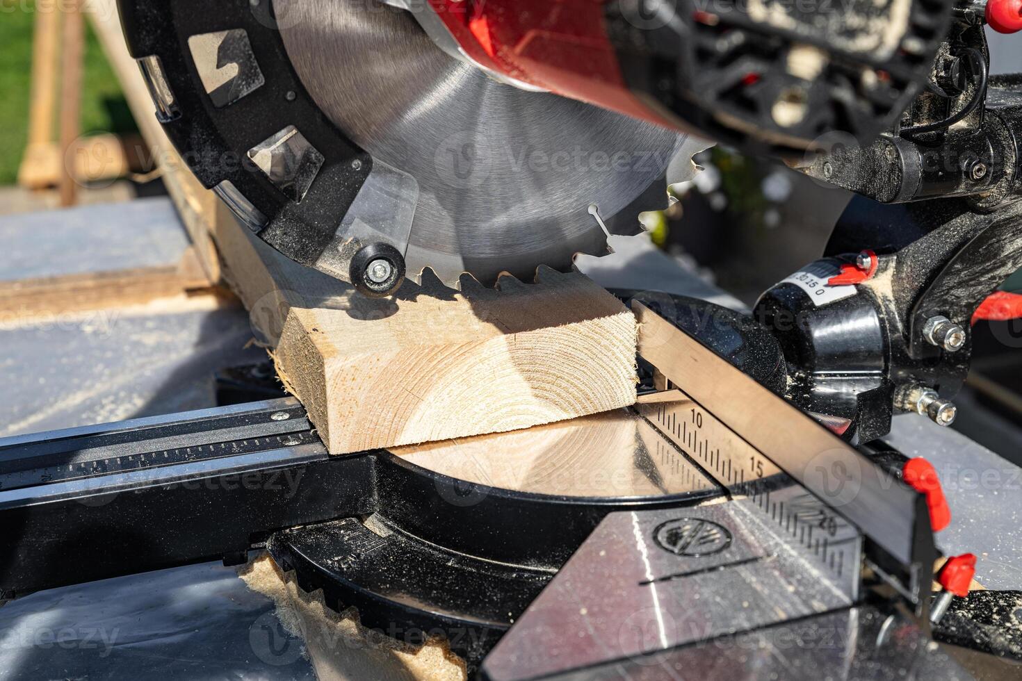 Using a miter saw to cut a piece of wood. Own carpentry workshop. Sawing a wooden board with a miter saw. Safe equipment for the furniture and construction industry. Close-up. photo