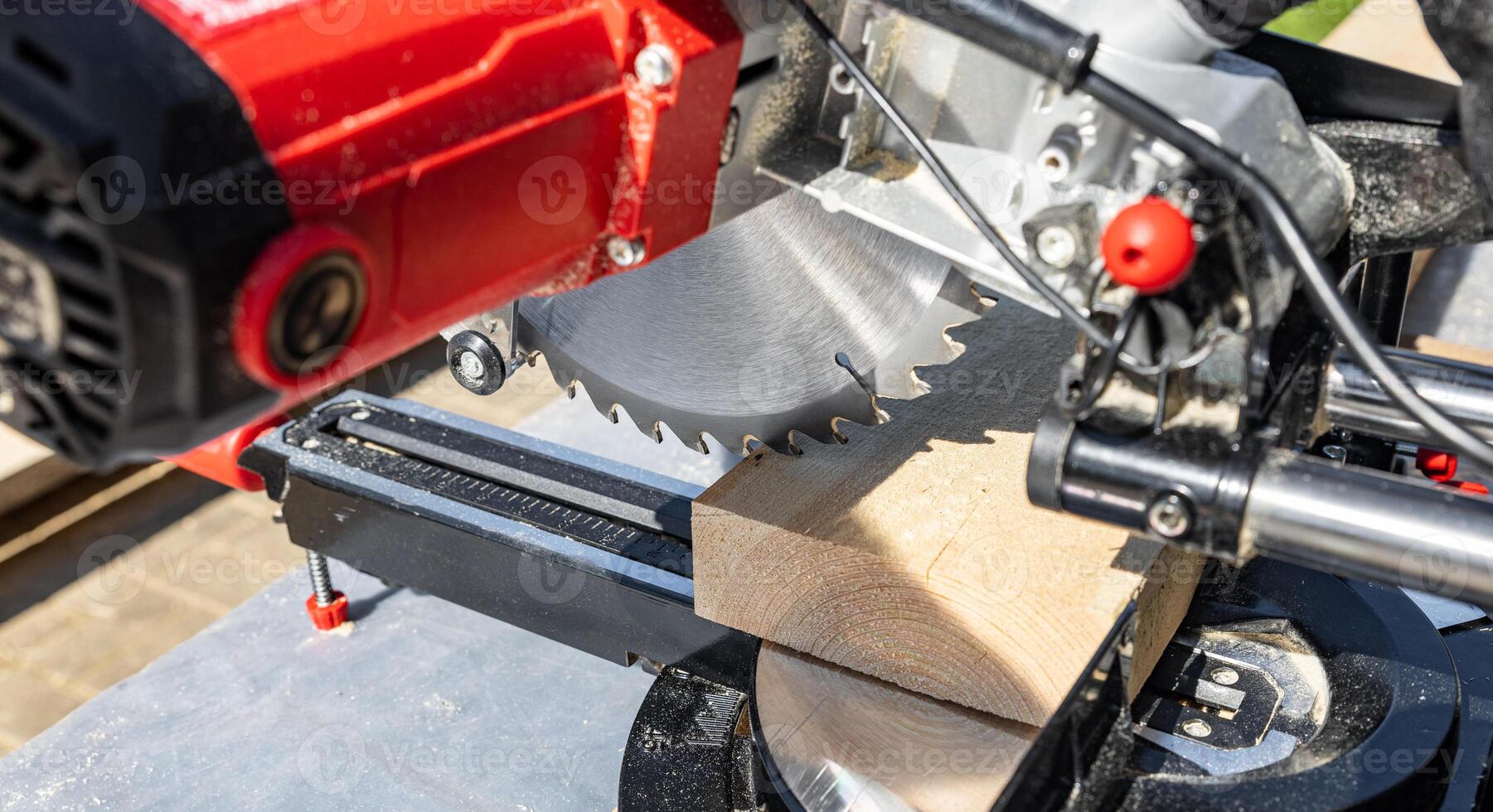 Cuts a wooden beam using a circular saw. Home furniture workshop. Work in his carpentry workshop. Miter saw and planks for building a house. photo