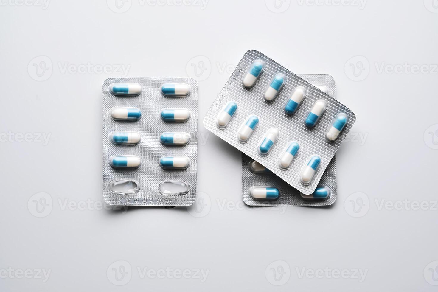 Packs of white and blue capsules of medical preparations on a white background. photo