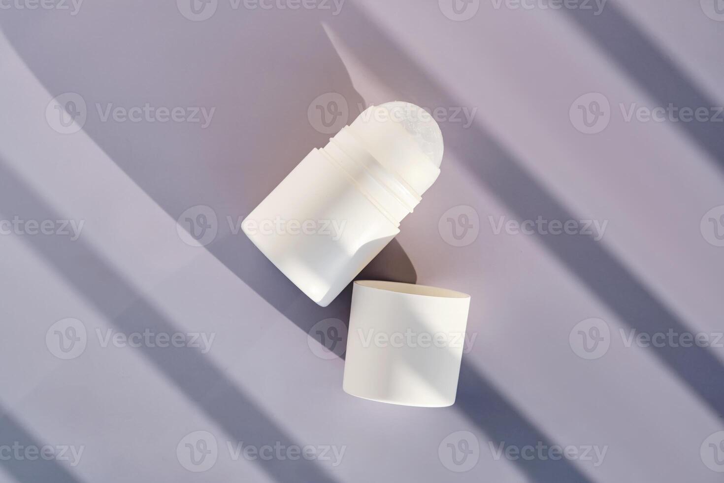 Roll-on deodorant on a purple background with shadow stripes. photo