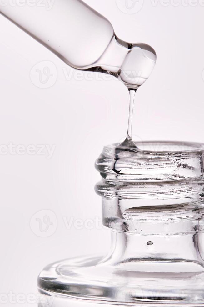 Close-up of a cosmetic bottle with a pipette showing the texture of the serum. photo