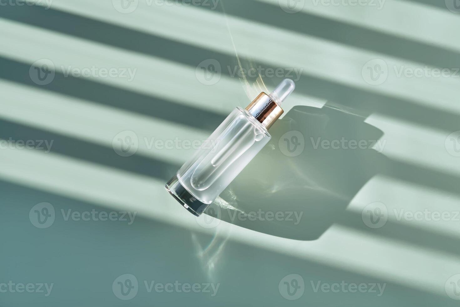Bottle of cosmetic serum with pipette on green background with shadow stripes. photo