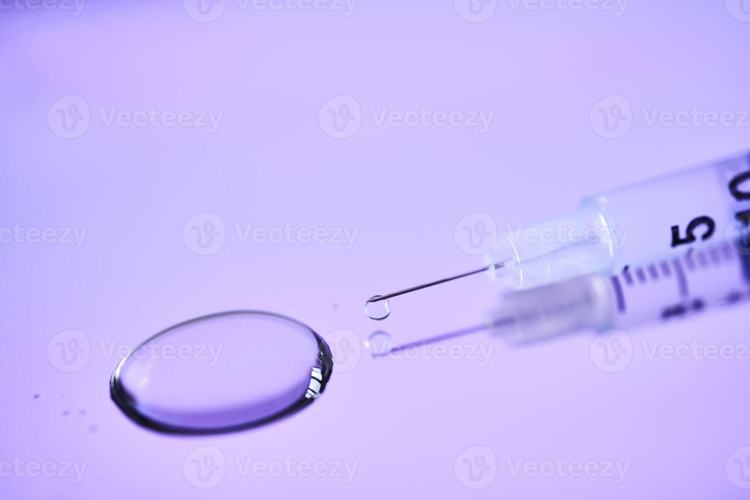 Injection syringe on a medical tray in bright violet color. photo