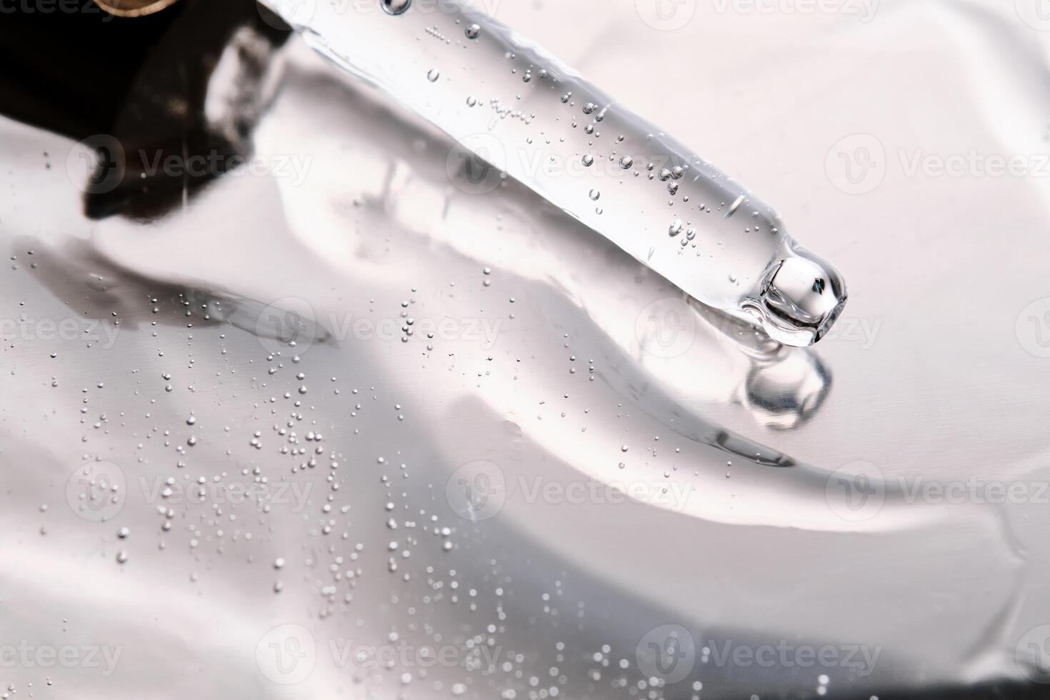 Dropper pipette with delicious serum with bubbles on the gel texture. photo