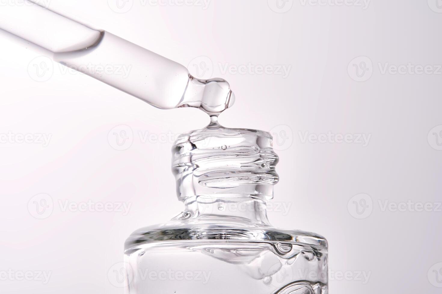 Close-up of a cosmetic bottle with a pipette showing the texture of the serum. photo