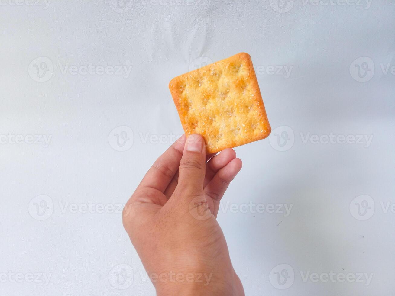 Sugar coated biscuits, also known as malkist, sweet and crispy. held by Asian woman's hand and isolate on white photo