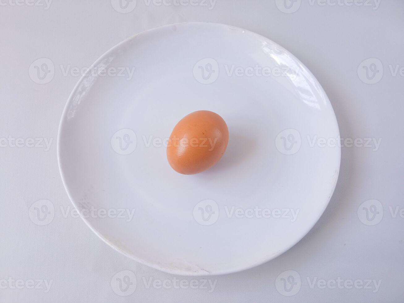 chicken egg on a round white plate isolate on white. vegan concept. protein rich food. diet menu photo