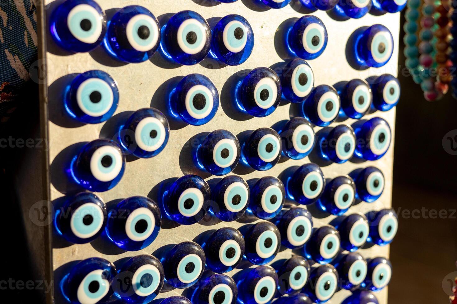 Unique collection of blue evil eye charms displayed in a market setting during daylight photo