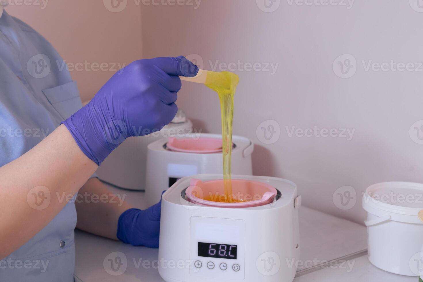 Waxing process in a beauty salon with warm wax and an applicator in use during daylight photo