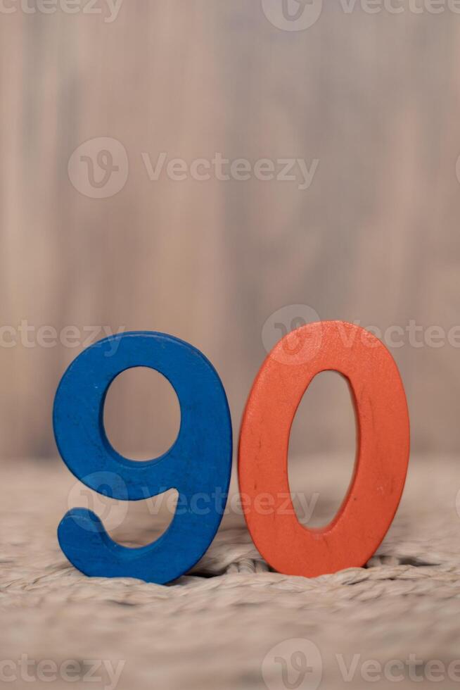 Close-up wooden figure number ninety on a beige blurred background photo