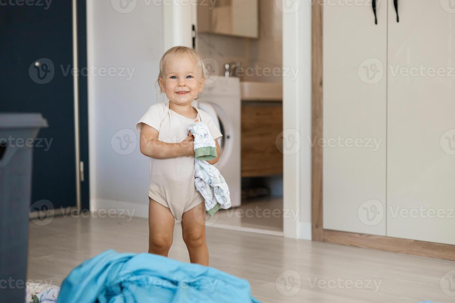 small caucasian child daughter helps mother with a laundry photo