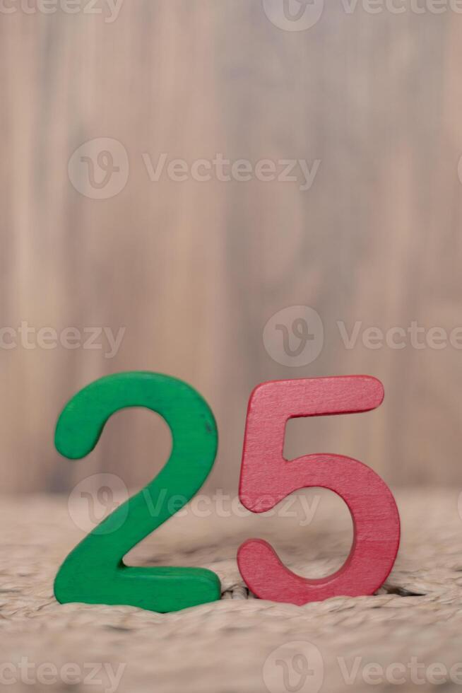 Close-up wooden figure number twenty five on a beige blurred background photo