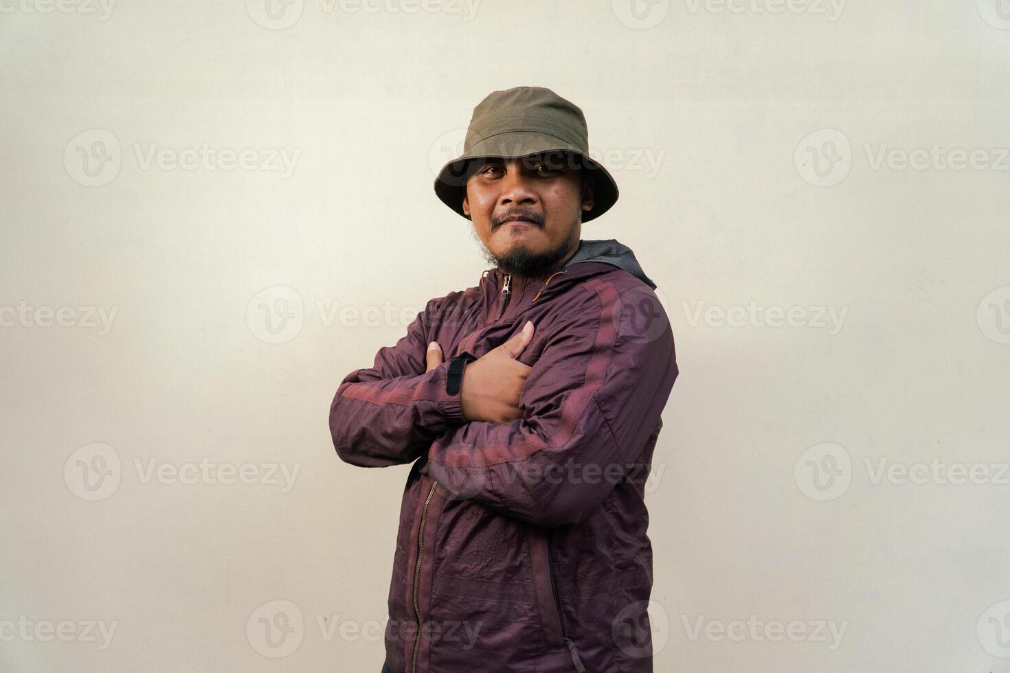 Half body of adult Asian man with beard and mustache is posing in various styles. Mature macho man wearing adventure outfit with jacket and bucket hat isolated on beige background. photo