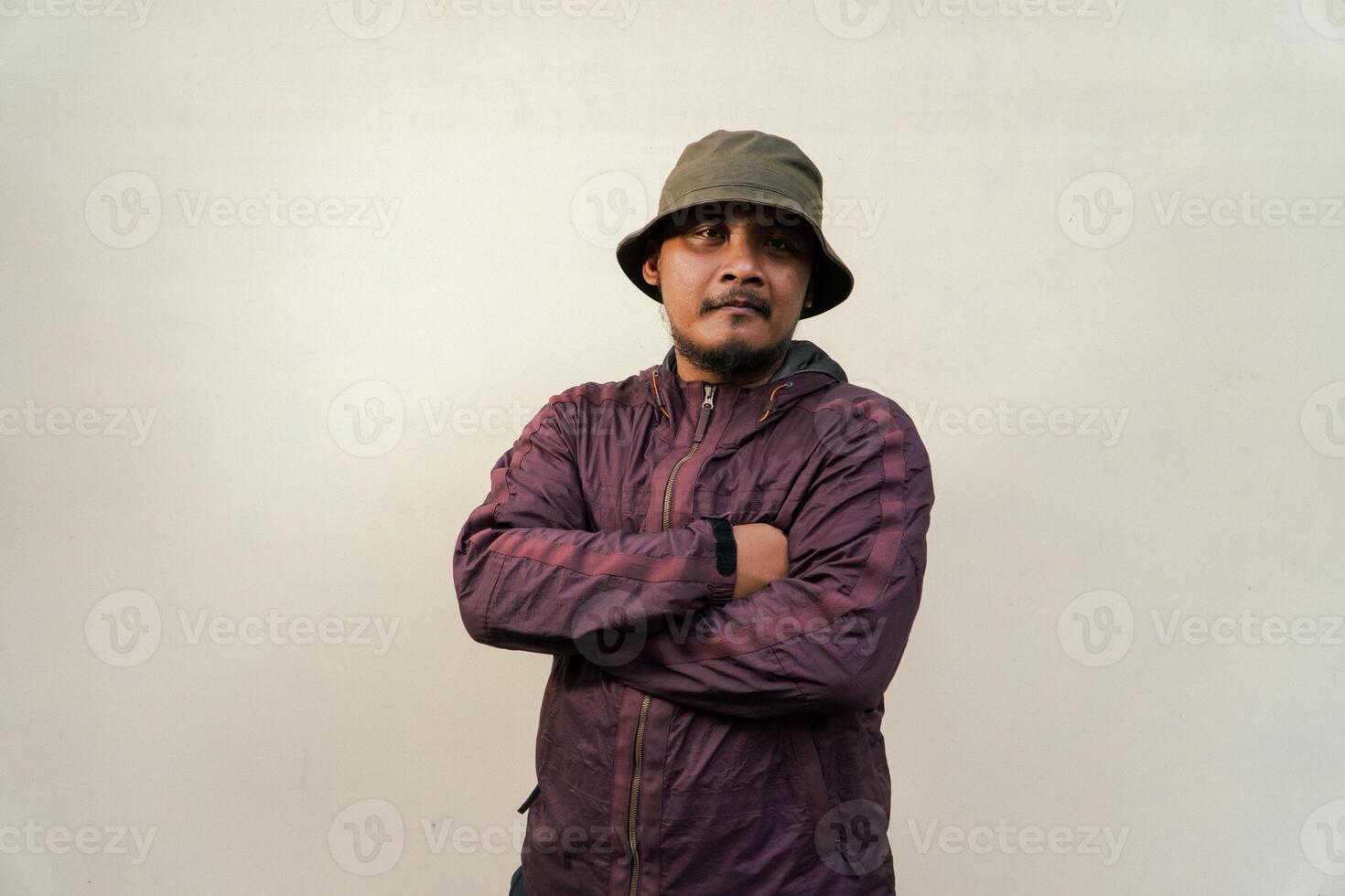 Half body of adult Asian man with beard and mustache is posing in various styles. Mature macho man wearing adventure outfit with jacket and bucket hat isolated on beige background. photo