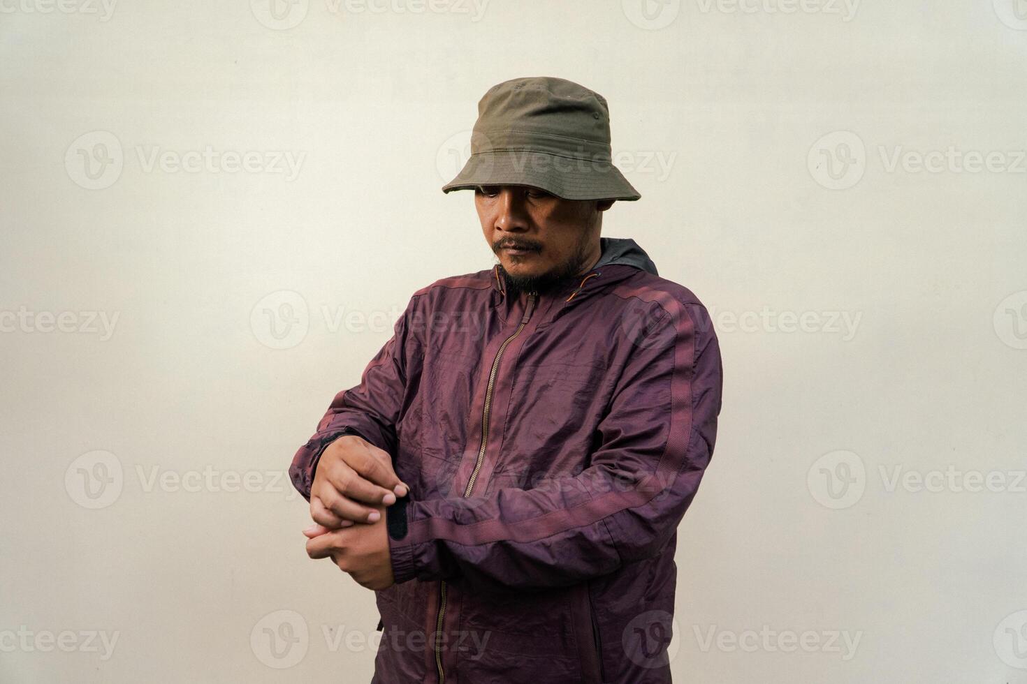 Half body of adult Asian man with beard and mustache is posing in various styles. Mature macho man wearing adventure outfit with jacket and bucket hat isolated on beige background. photo