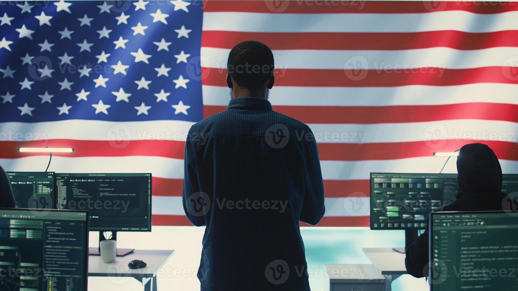 Cyber defense experts in a governmental tech room with the American flag. Working on secure computing, digital forensics and cyber operations to protect and maintain cyber safety. Camera B. photo