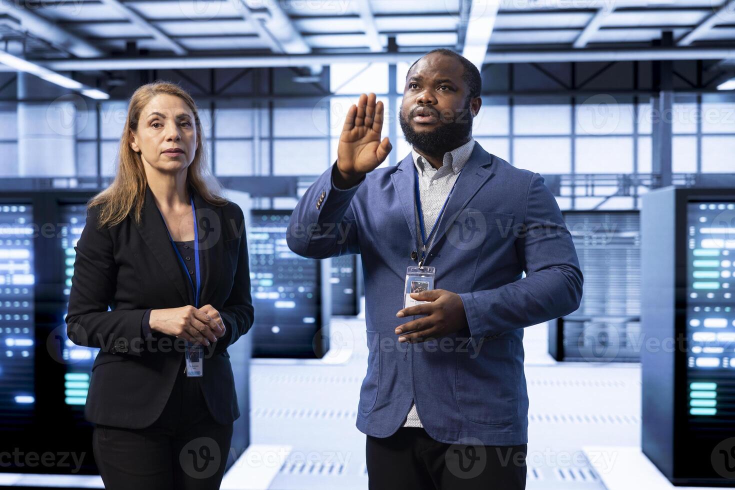 Coworkers in data center checking rigs and hardware, doing checkup with AR tech. IT staff members planning and executing server room migrations and upgrades using augmented reality photo