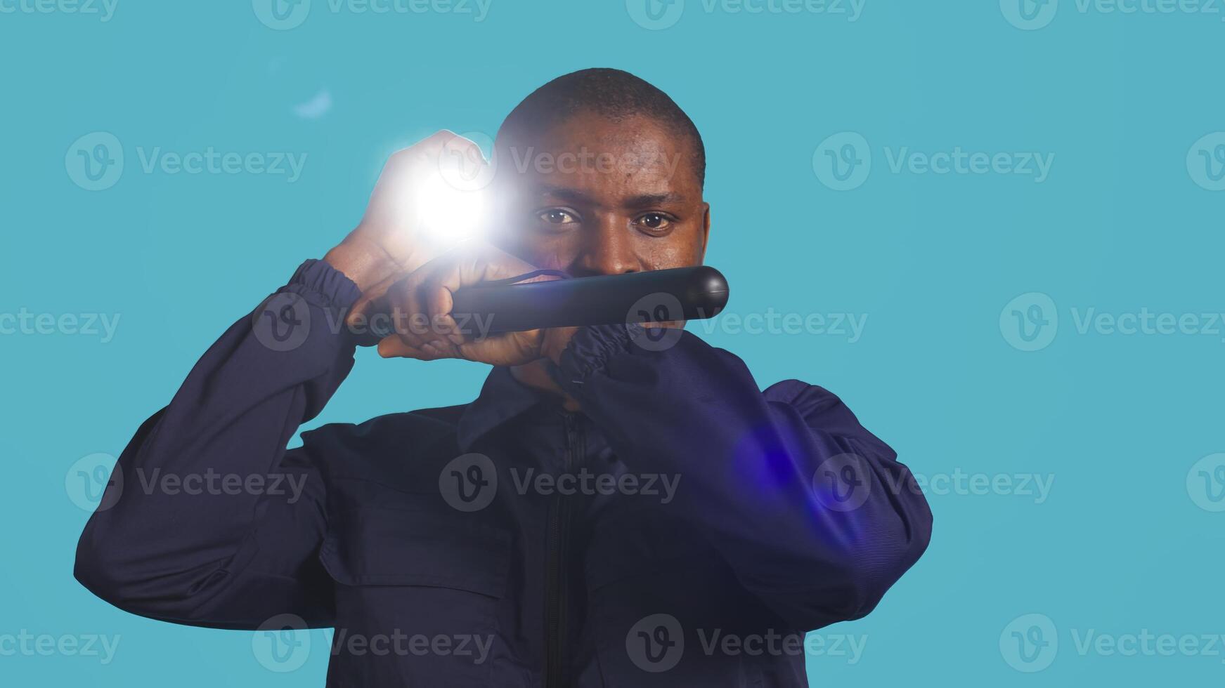 Headshot portrait of security staff member evicting trespassers with baton after spotting them with flashlight. Close up of patrolling agent using truncheon and lantern to evict intruders, camera B photo