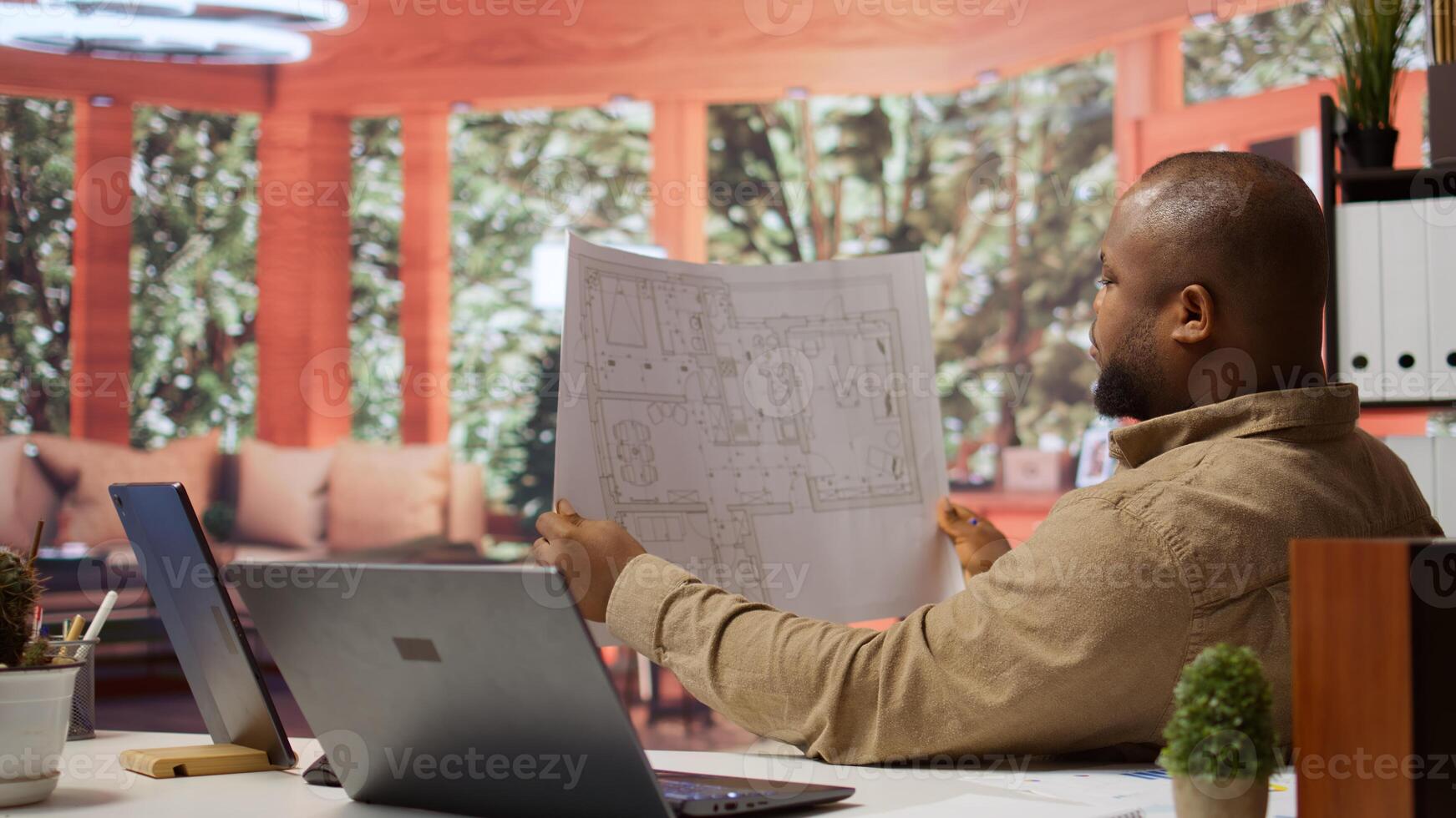 Corporate owner planning an office interior design renovation, reviewing blueprints and collaborating with contractors to create a modern workspace. Evaluating property sketches at home. Camera B. photo