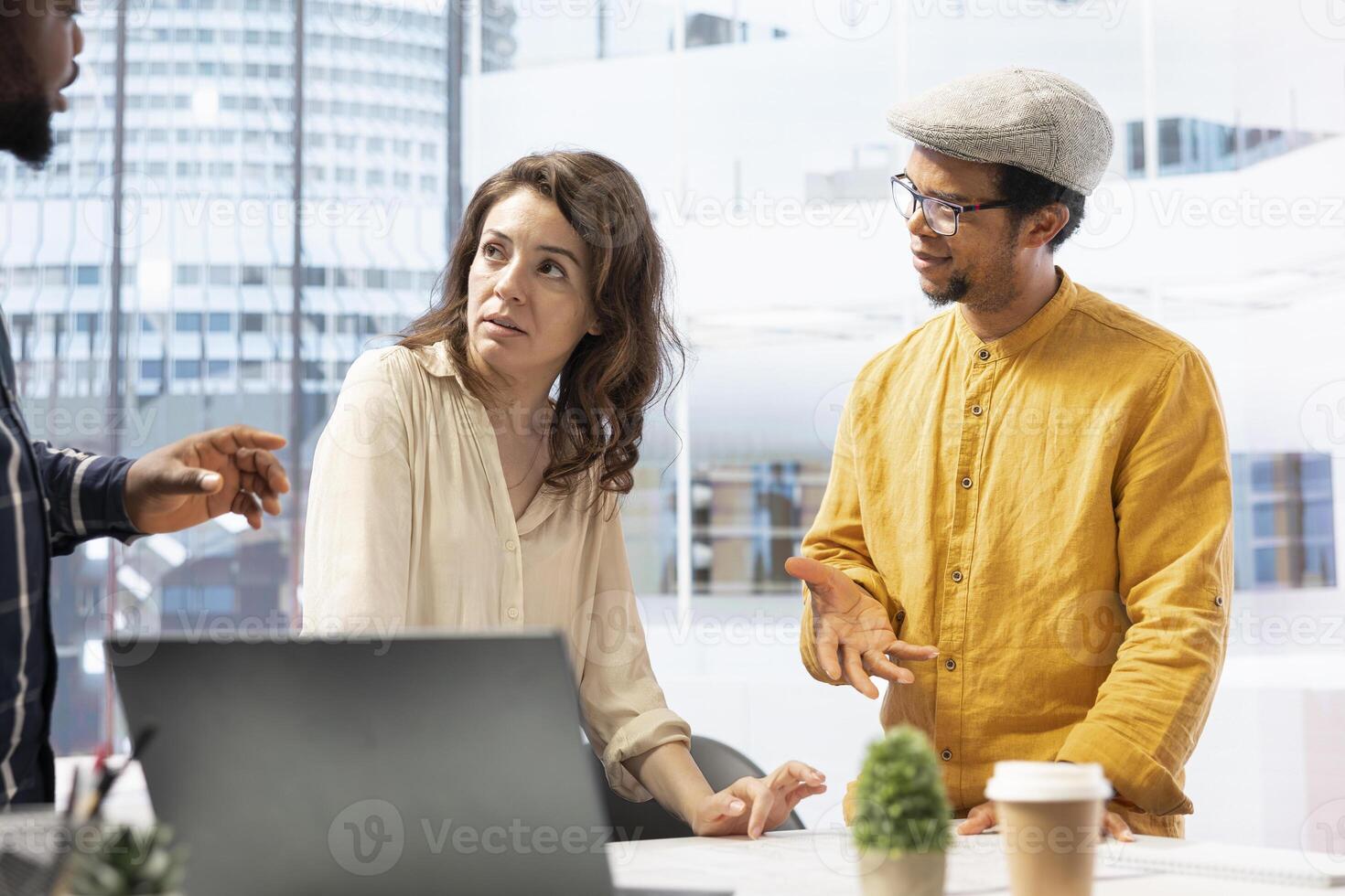 Real estate agent advises business people on property investment opportunity, using blueprints to plan the layout of a modern high class office space. Clients agreeing on rental contract. photo
