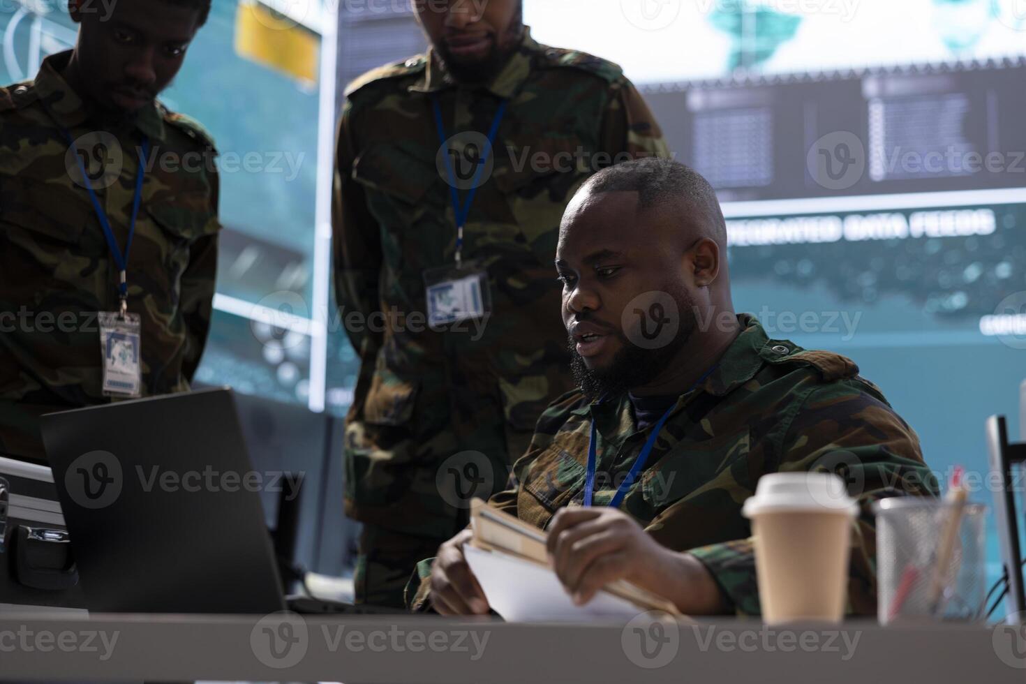 Team of military specialists monitor satellite data and integrates live information, coordinates strategic missions to support decision making and national defense in a high tech command post. photo