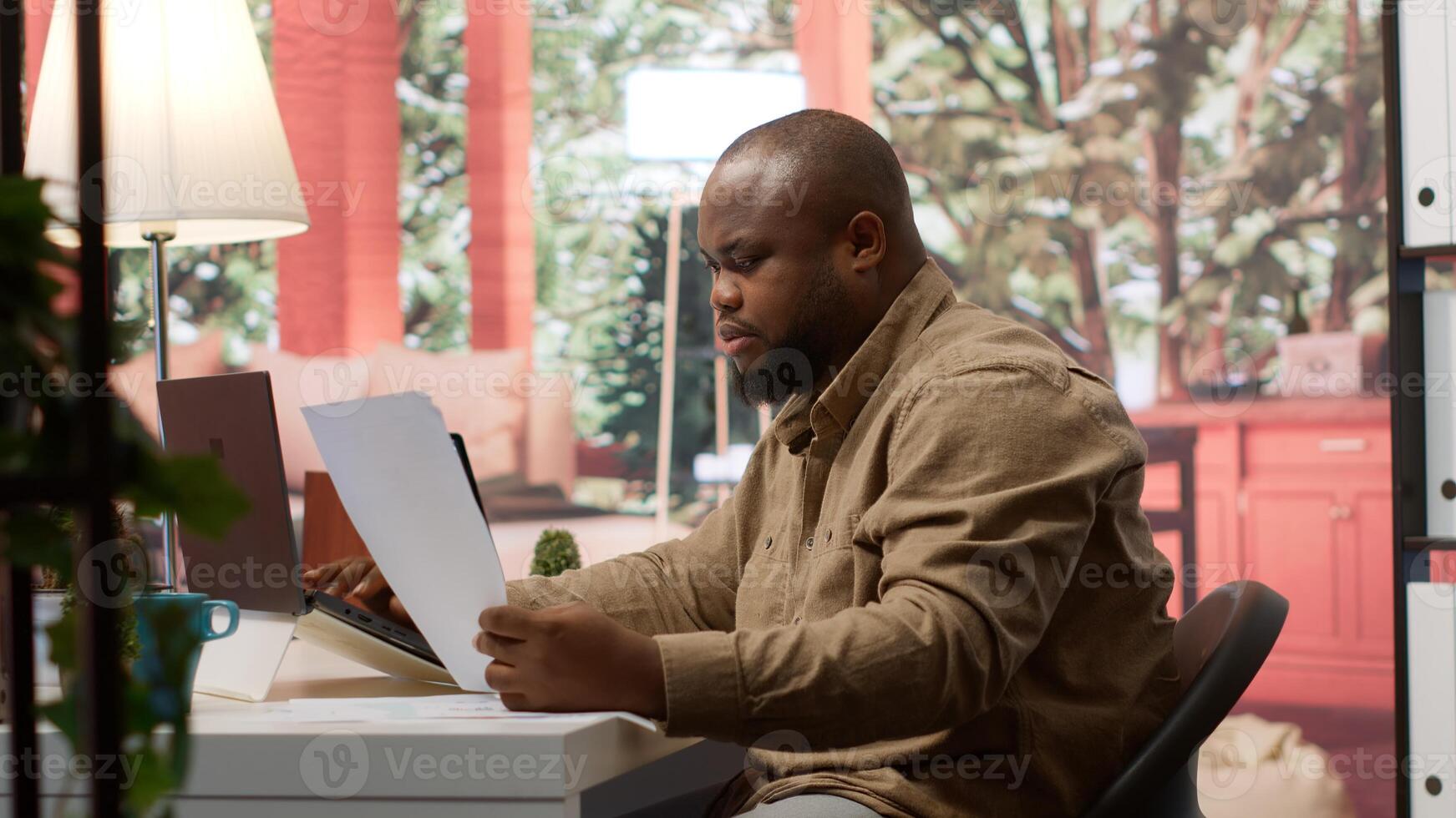 Startup entrepreneur calculating the annual sales reports to review the budget, working to develop the business activity. Businessman analyzing profit and expenses on his laptop at home. Camera A. photo