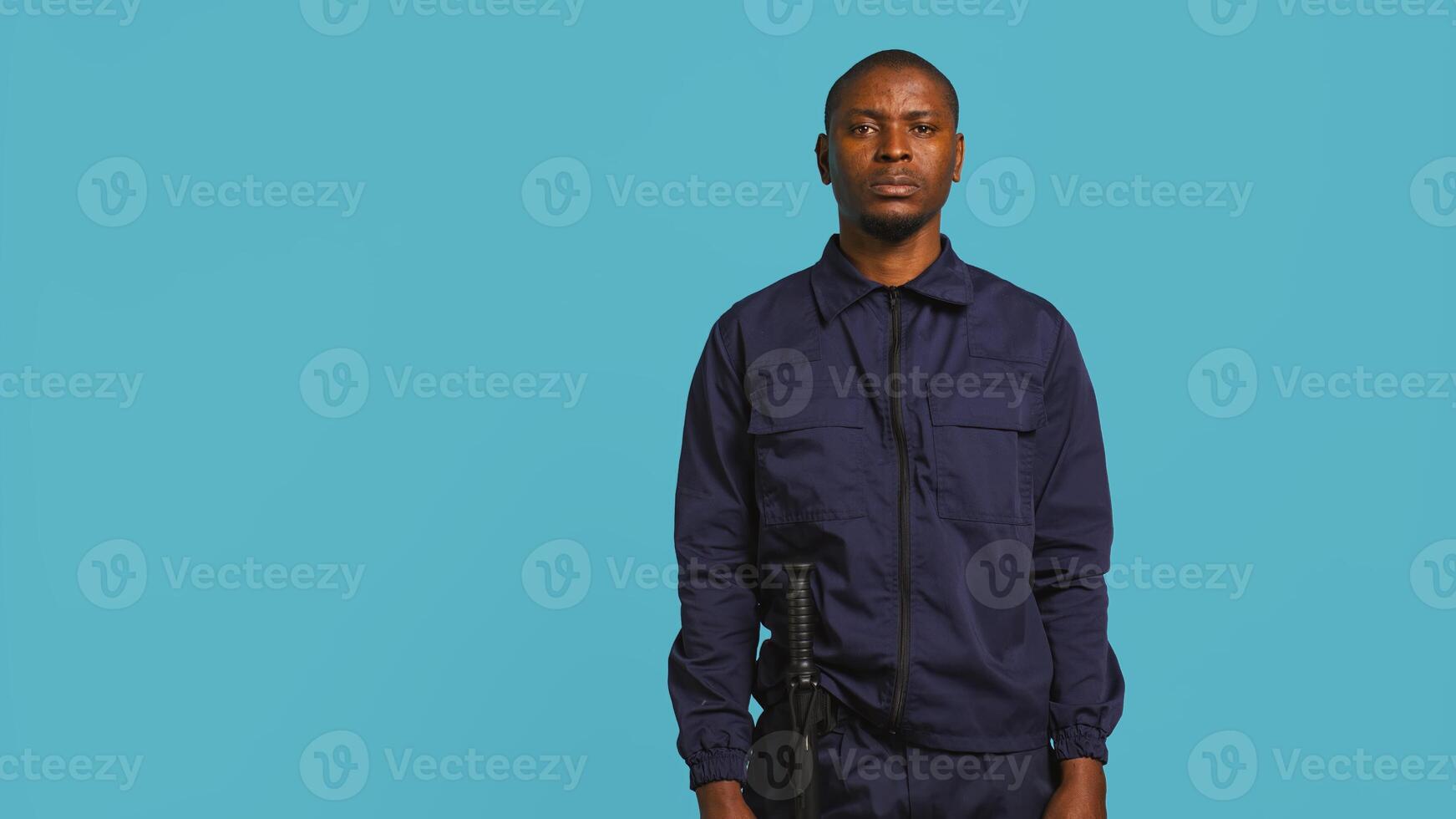 Security guard tasked with preventing criminal activity and detaining suspects stealing, damaging property, or performing other crimes. Portrait of intimidating bodyguard, studio background, camera B photo