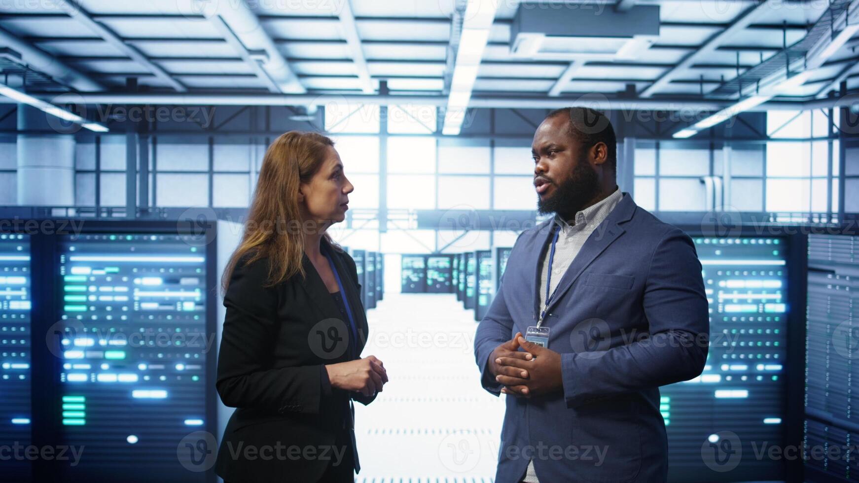 African american expert and coworker looking at holograms in data center, working together. Team members interacting with augmented reality AI visualization in server hub, camera B photo