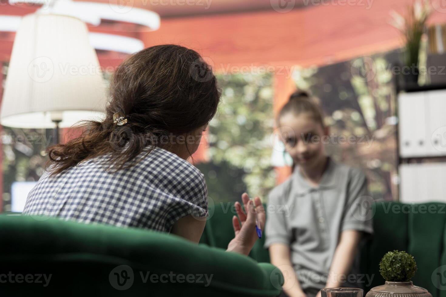 Adolescent girl talking about her struggles with mental health in a therapy session. Psychotherapist helps her navigate depression and the emotional challenges of hormonal shifts. photo