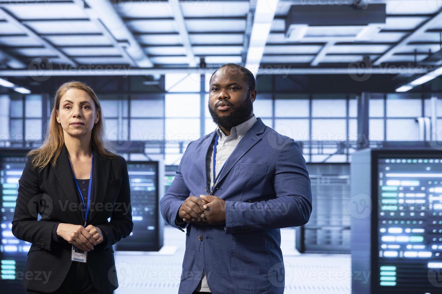 Teamworking supervisors overseeing data center after configuring network infrastructure such as routers, switches and firewalls. Coworkers in server room looking for technical bugs photo